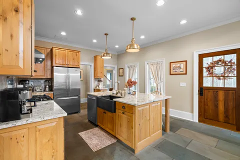 a kitchen with stainless steel appliances granite countertop a sink a stove and a refrigerator