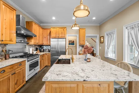 a kitchen with stainless steel appliances granite countertop a sink stove and refrigerator