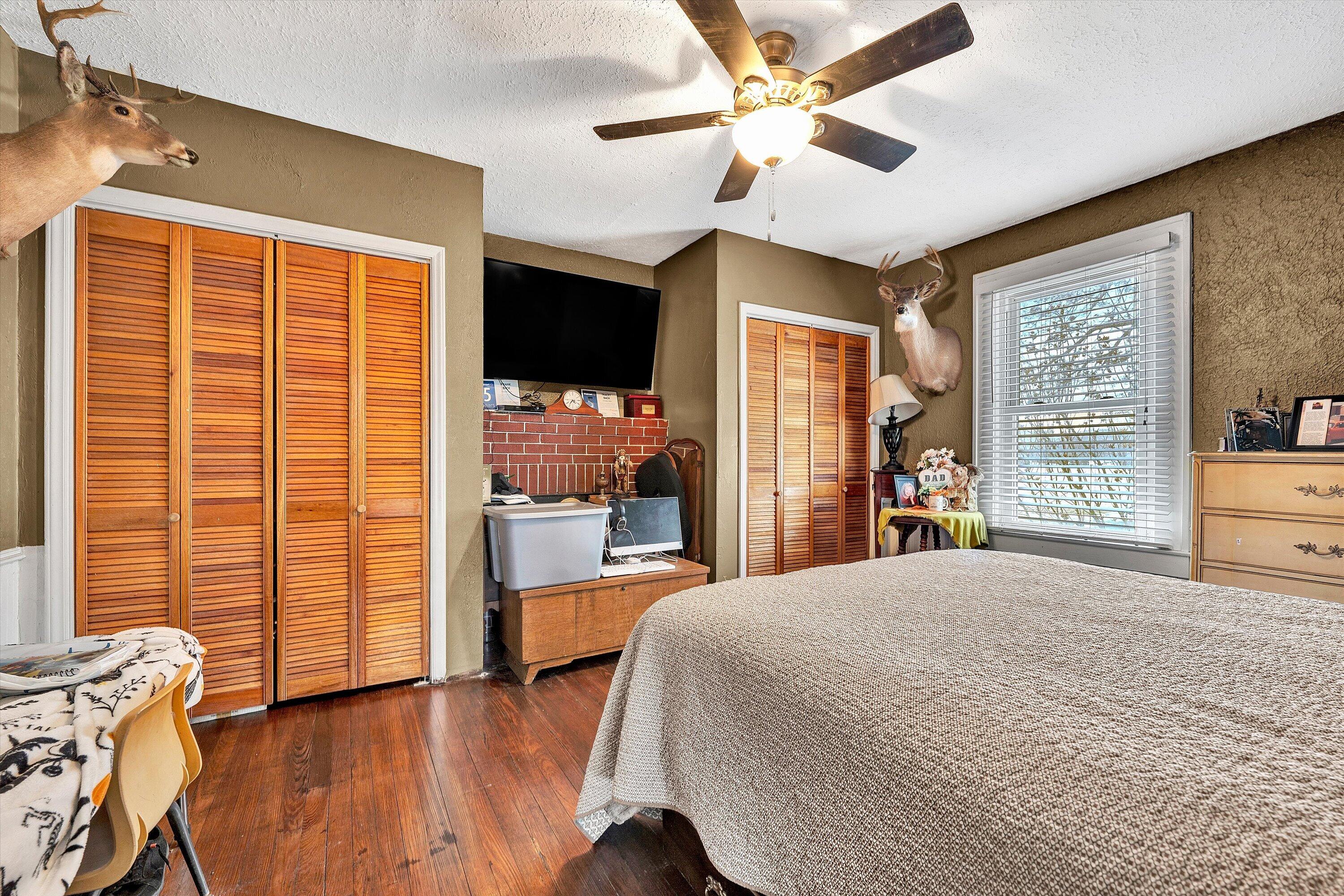 1045 Emerald Drive Goodview, VA 24095 - Photo 19 of 46 a spacious bedroom with a large bed and a chandelier
