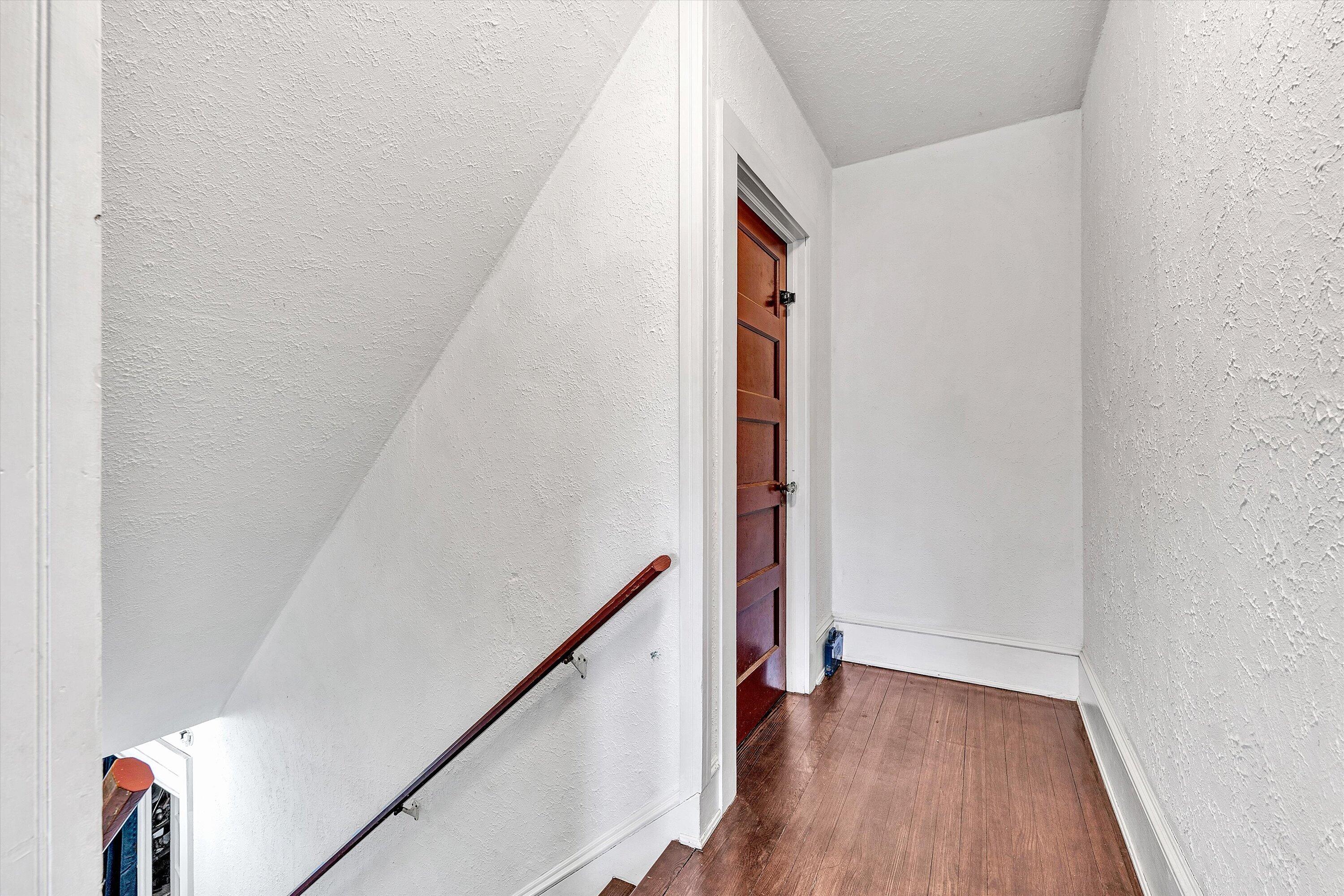 1045 Emerald Drive Goodview, VA 24095 - Photo 22 of 46 a view of a hallway with wooden floor and staircase