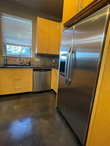 a kitchen with stainless steel appliances granite countertop a refrigerator and a sink