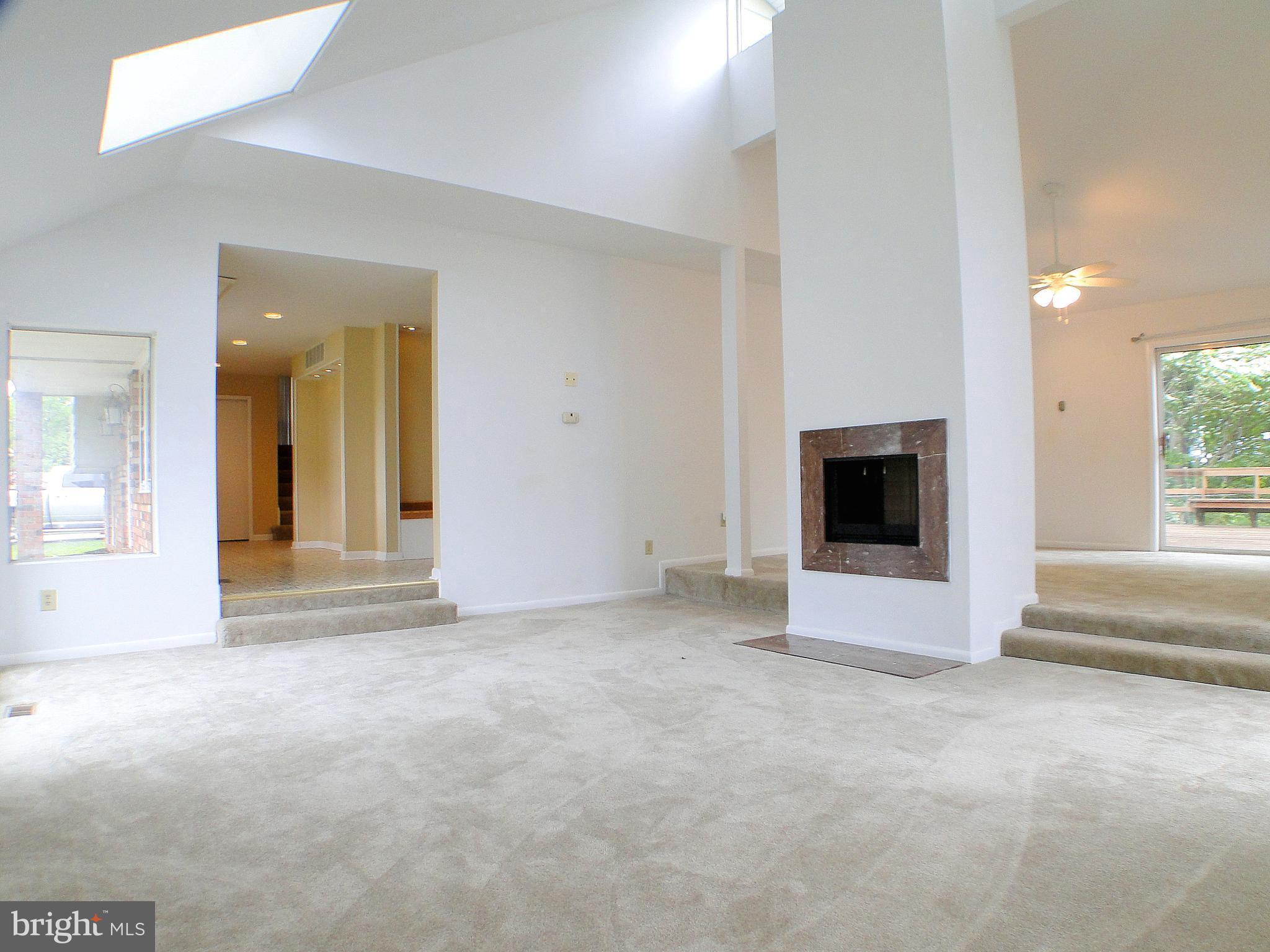 8232 Brattle Road Pikesville, MD 21208 - Photo 3 of 30 a view of an empty room with a fireplace and a window