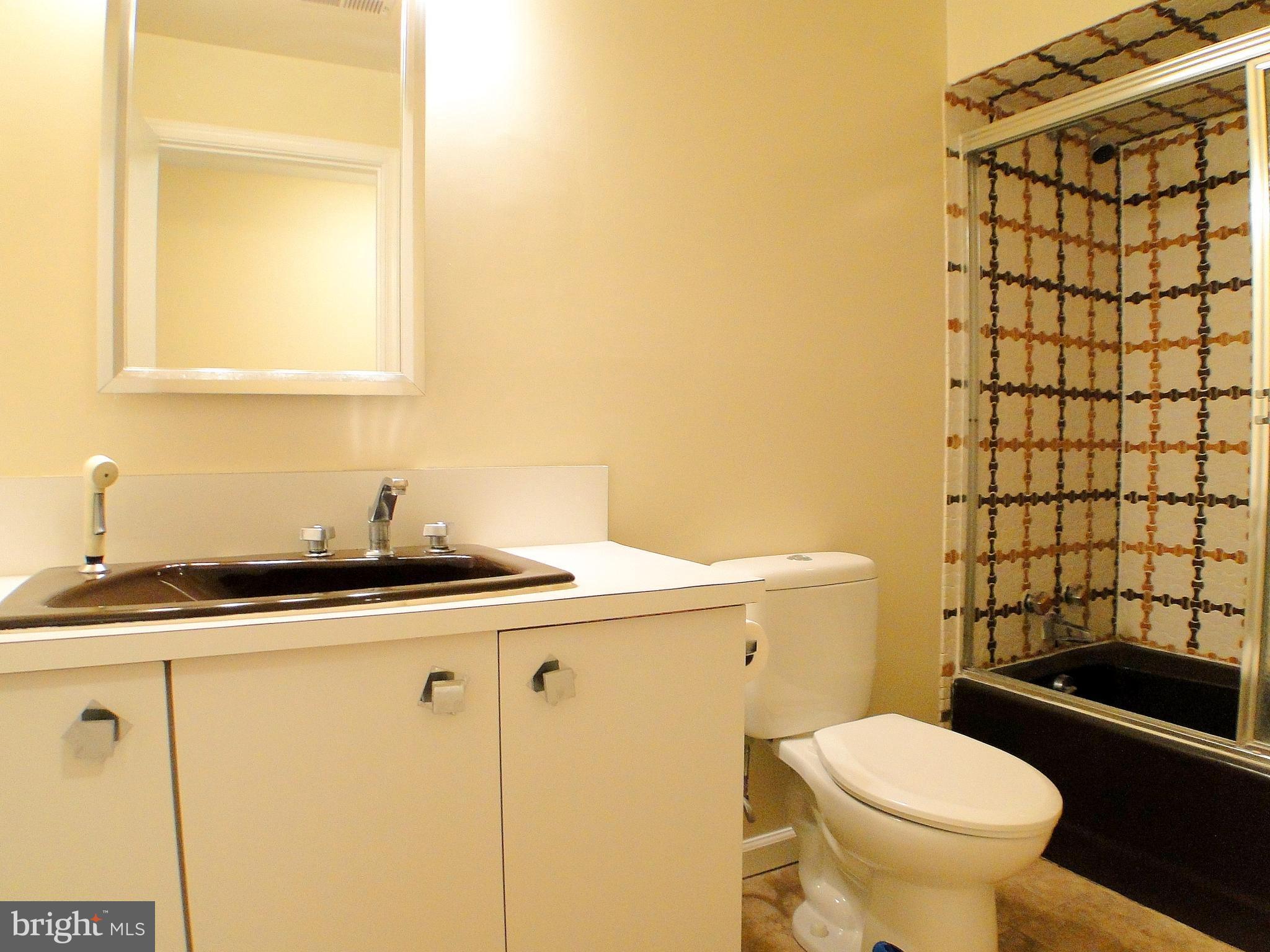 8232 Brattle Road Pikesville, MD 21208 - Photo 26 of 30 a bathroom with a sink toilet and shower