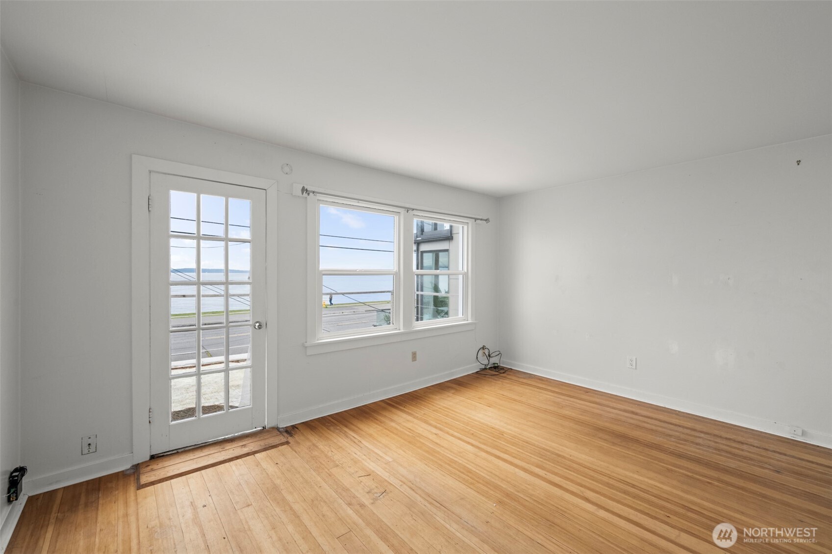 1768 Alki Avenue Southwest Seattle, WA 98116 - Photo 25 of 40 an empty room with wooden floor and windows