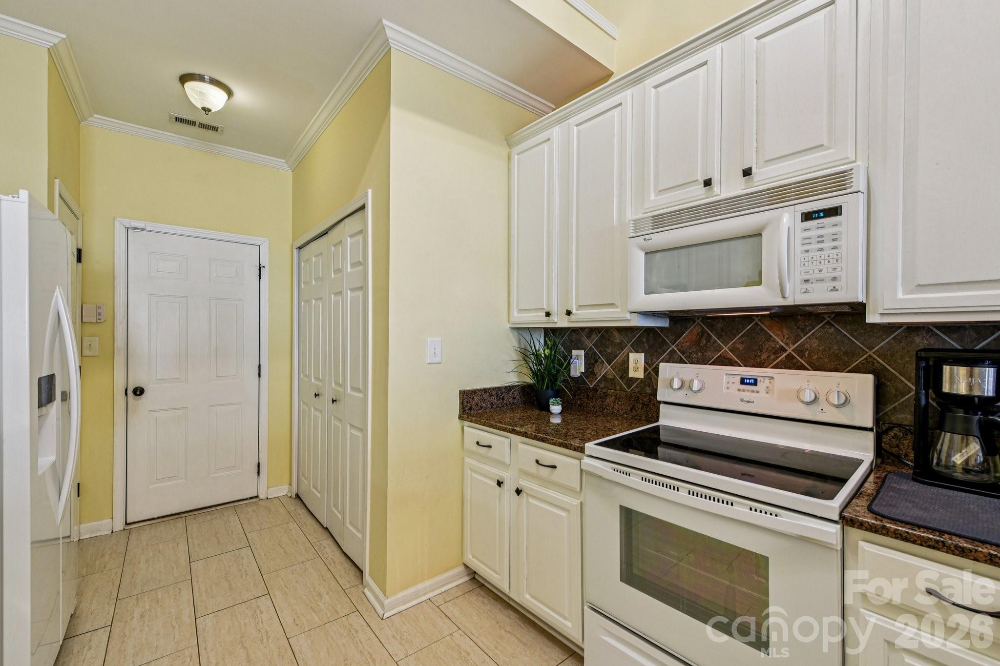4700 Willow Glen Road Harrisburg, NC 28075 - Photo 8 of 29 a kitchen with stainless steel appliances granite countertop a stove a microwave and a refrigerator