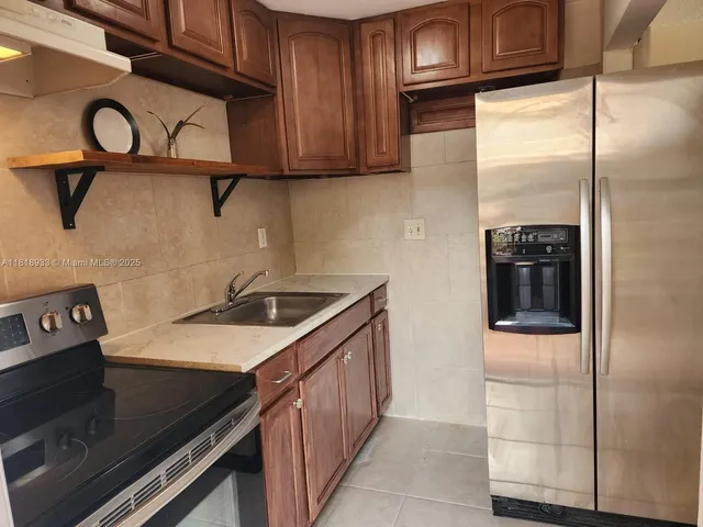 a kitchen with stainless steel appliances granite countertop a refrigerator and a stove