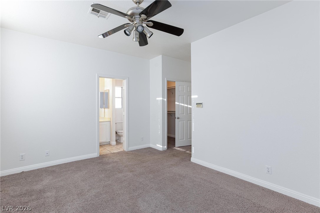 2246 Ramsgate Drive Henderson, NV 89074 - Photo 15 of 36 A spacious bedroom featuring comfortable carpeting and a ceiling fan for year-round comfort.