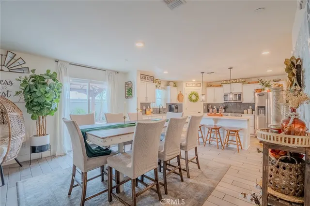 a kitchen with stainless steel appliances a refrigerator a sink dishwasher a stove and white cabinets with wooden floor