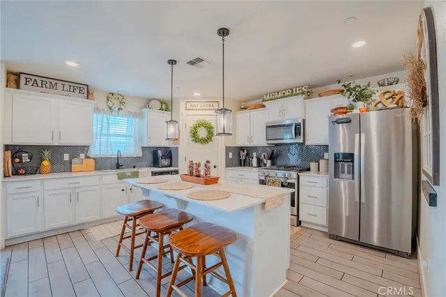 a kitchen with a table chairs refrigerator and cabinets