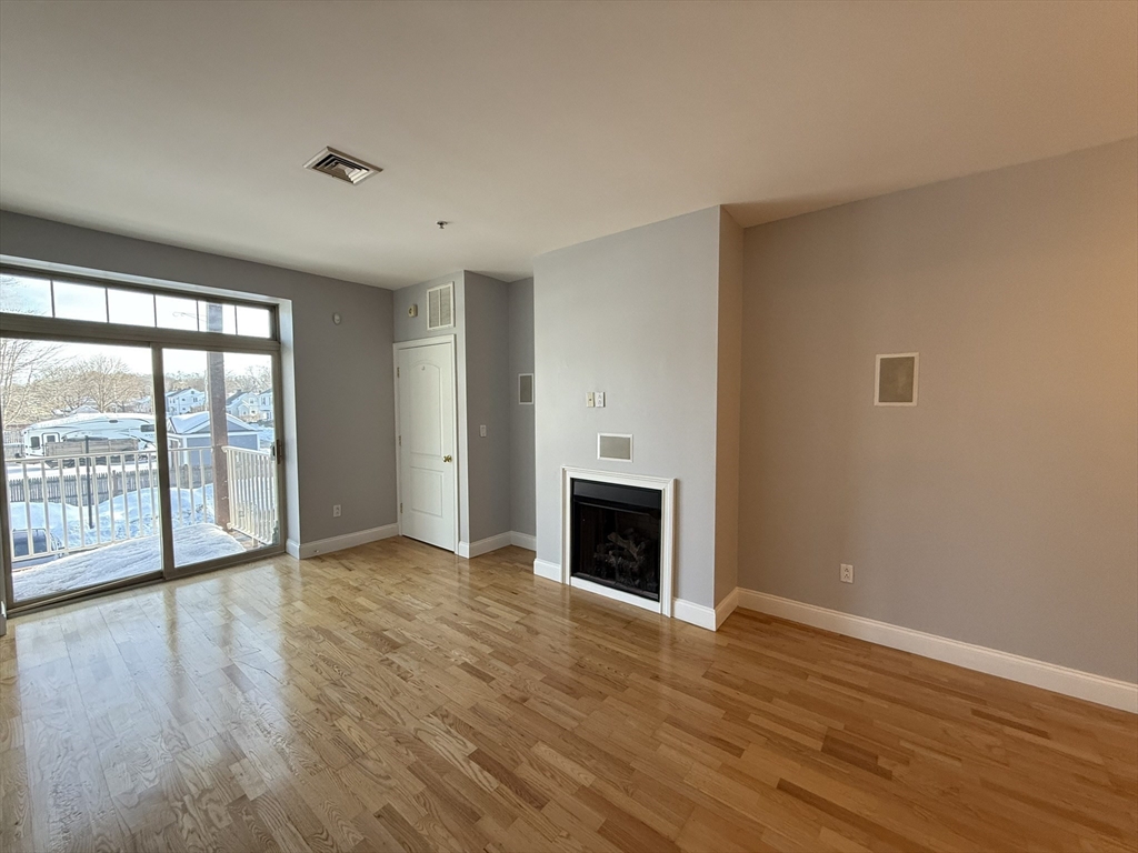 40 Heather Street, Unit 204 Beverly, MA 01915 - Photo 4 of 39 a view of an empty room with wooden floor and a window