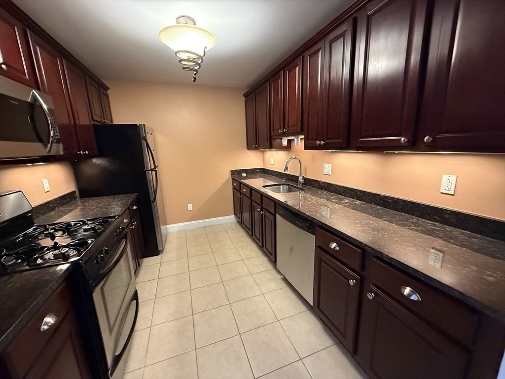 40 Heather Street, Unit 204 Beverly, MA 01915 - Photo 7 of 39 a kitchen with granite countertop stainless steel appliances a sink stove top oven and cabinets