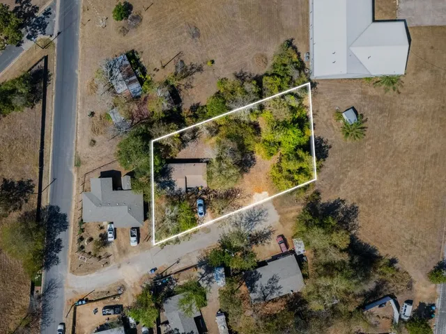 an aerial view of a house a yard and mountain
