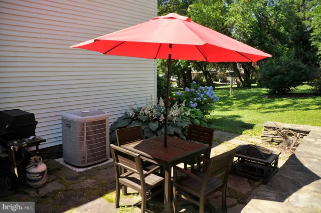 a view of a patio with table and chairs under an umbrella