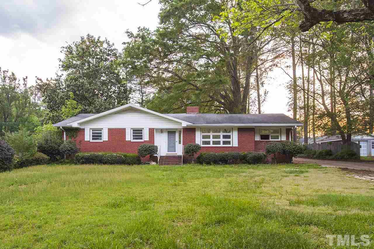 5612 Old Stage Road Raleigh, NC 27603 - Photo 1 of 5 a house that is sitting in the grass with large trees and plants