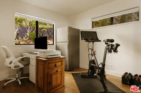 a view of a workspace with furniture and a window