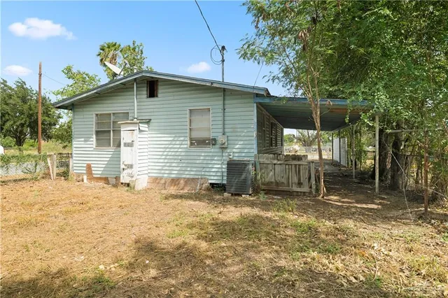 a backyard of a house with table and chairs