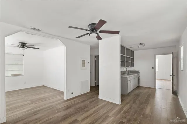 a view of a room with wooden floor and a ceiling fan