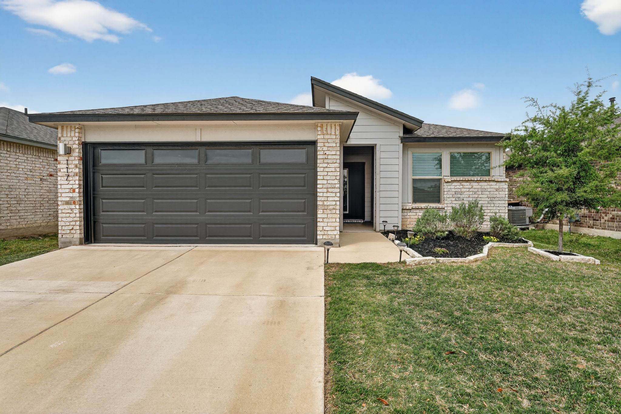 117 Halford Road Georgetown, TX 78633 - Photo 2 of 31 View of front facade with brick siding, concrete driveway, an attached garage, a front yard, and a shingled roof