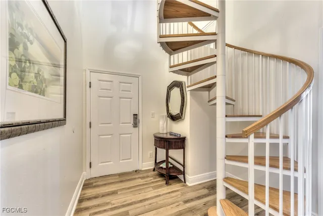 a view of a hallway with wooden floor and staircase