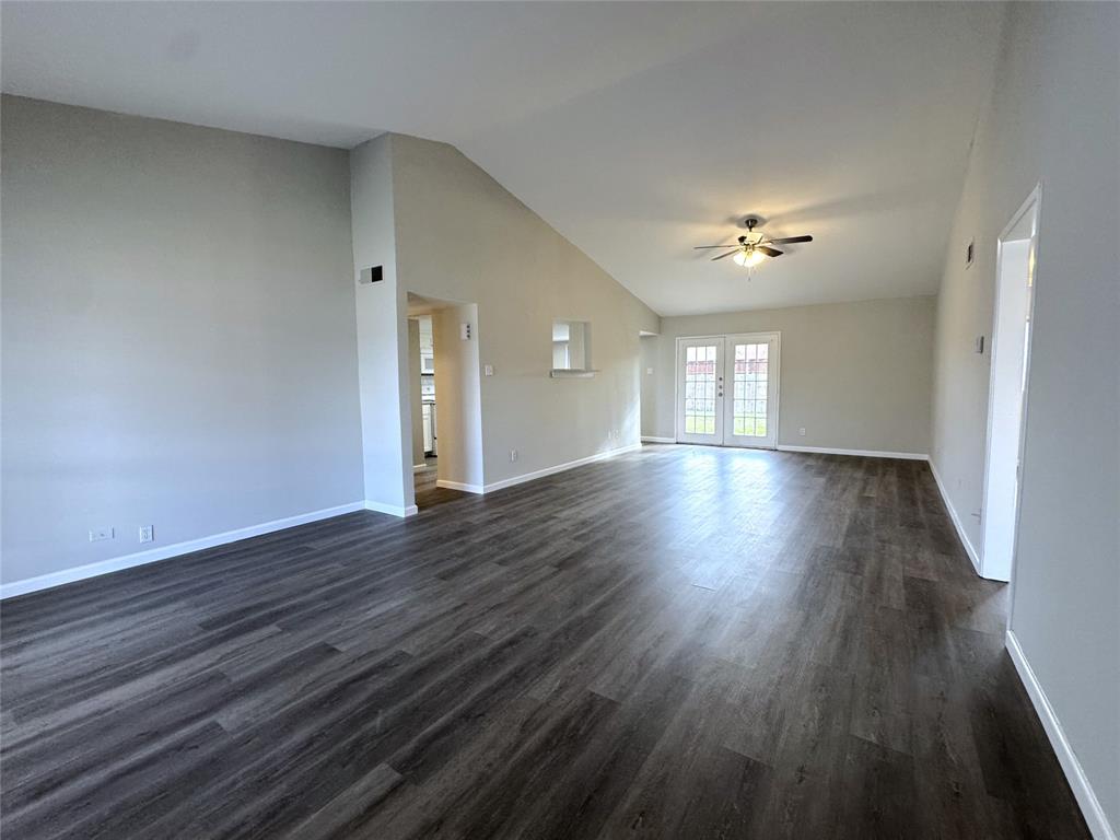 1612 Fairfield Drive Plano, TX 75074 - Photo 3 of 21 Living rooms have a vaulted ceiling, a fan, and a French door that opens to the spacious backyard.