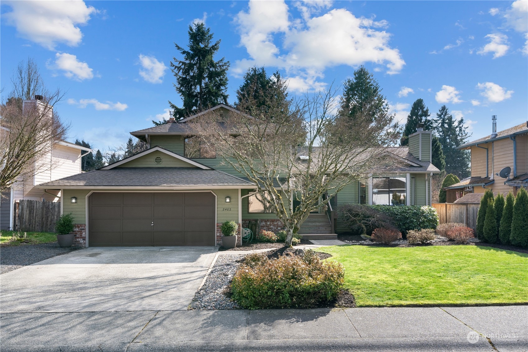 2402 169th Place Southeast Bothell, WA 98012 - Photo 1 of 38 a front view of a house with a yard and garage