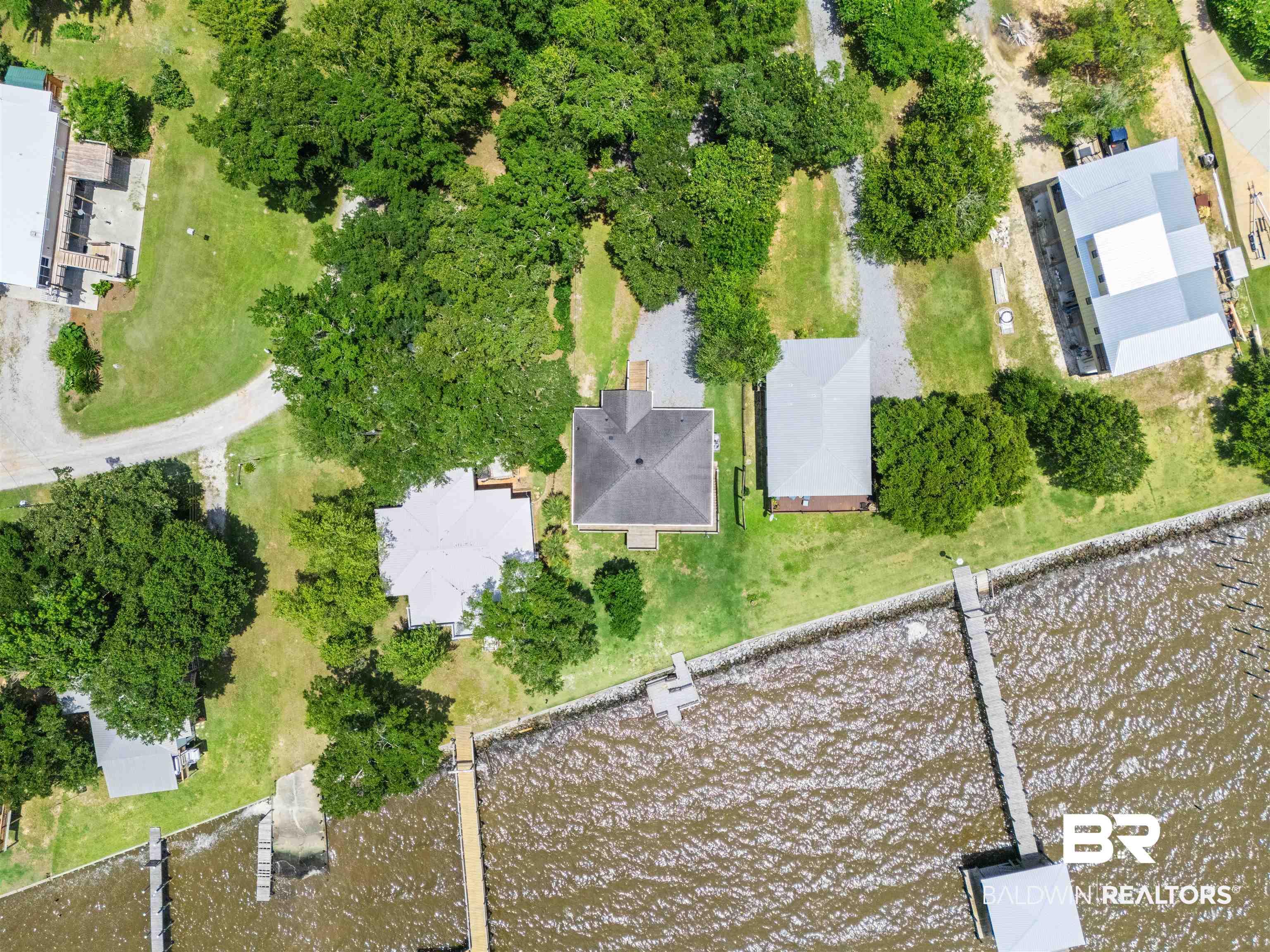 9581 South Bay Street Foley, AL 36535 - Photo 41 of 44 Aerial property perspective featuring a single-story residence with a dark-toned roof, multiple private docks, and a boat launch