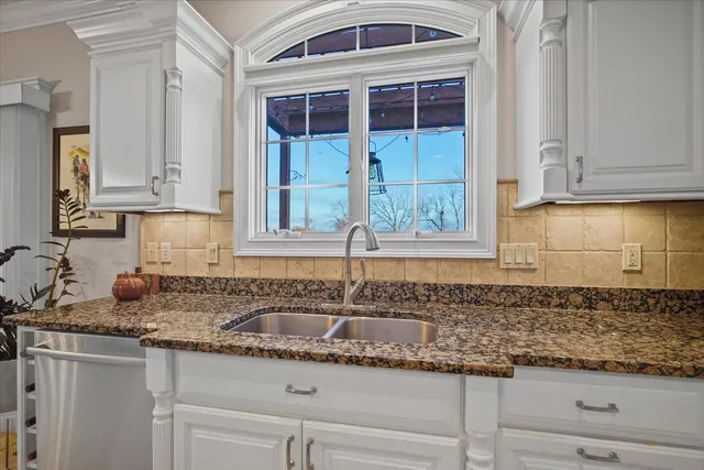 a kitchen with granite countertop a sink and cabinets