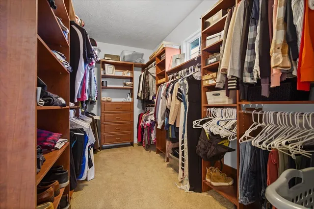 a view of walk in closet with clothes and shoes