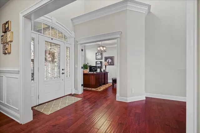 a view of a hallway with wooden floor and furniture