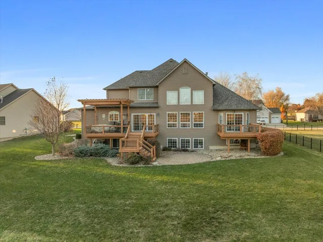 a view of a house with a big yard and large trees