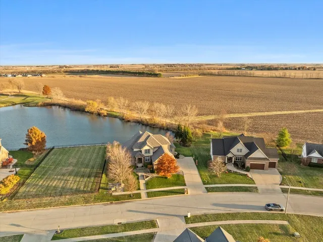 an aerial view of a house with a yard and lake view