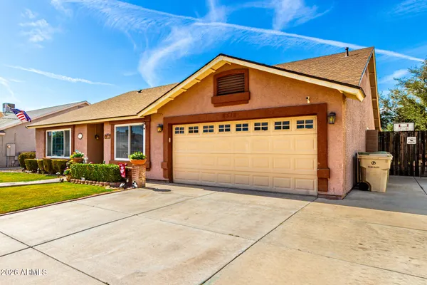 a front view of a house with a yard and potted plants