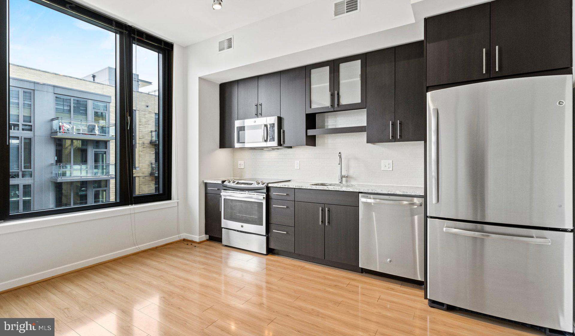8300 Wisconsin Avenue, Unit 2B1617 Bethesda, MD 20814 - Photo 88 of 150 a kitchen with granite countertop a refrigerator stove top oven and sink