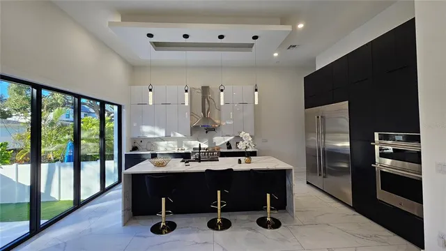 a living room with stainless steel appliances kitchen island granite countertop a sink and cabinets