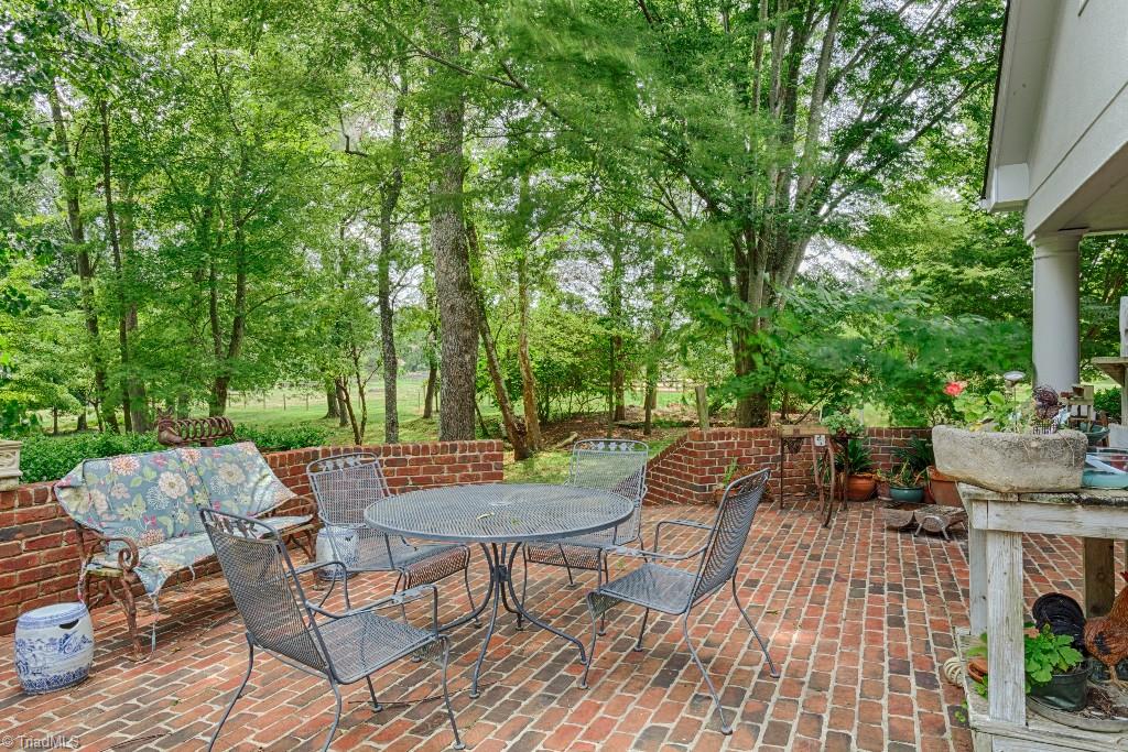 4426 Johnson Street High Point, NC 27265 - Photo 14 of 30 Private walled brick patio perfect for entertaining! Plum, fig, apple, pear, persimmons, apples, raspberries, blueberries, pomegraniates and more, in addition to 5-6 acres of pasture with yard hydrants. Gardeners dream.