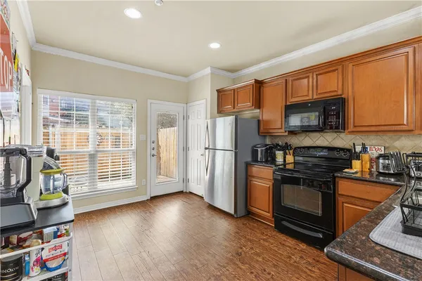 a kitchen with stainless steel appliances granite countertop a refrigerator stove top oven and sink