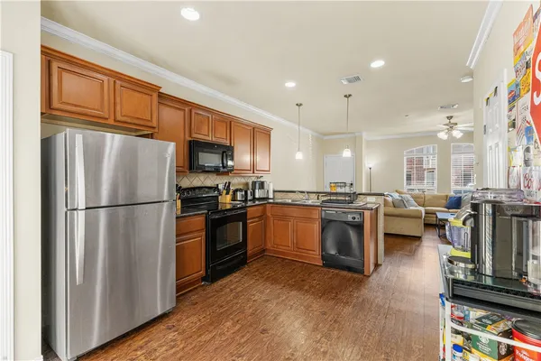 a kitchen with granite countertop a refrigerator stove top oven and sink