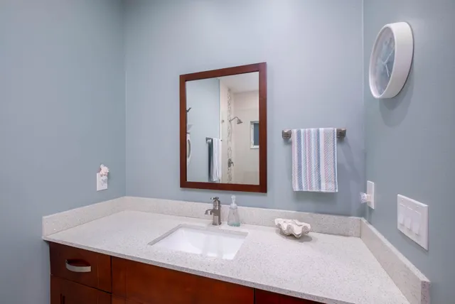 a bathroom with a granite countertop sink and a mirror