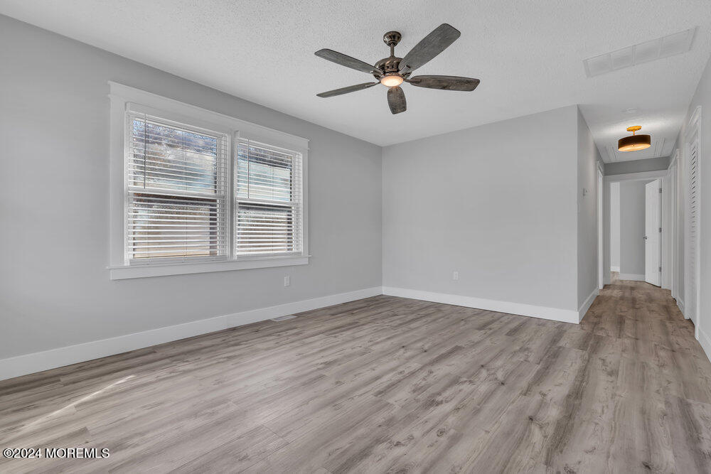 22 Spinnaker Way Waretown, NJ 08758 - Photo 11 of 29 a view of empty room with wooden floor and fan