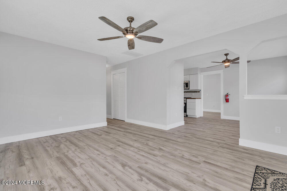 22 Spinnaker Way Waretown, NJ 08758 - Photo 12 of 29 an empty room with wooden floor and a ceiling fan