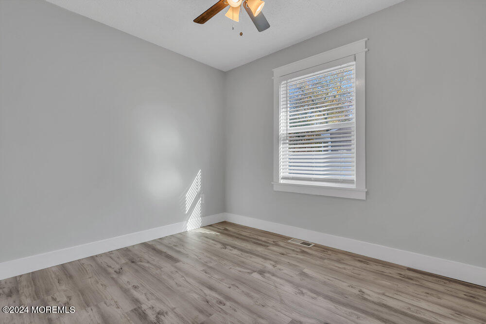 22 Spinnaker Way Waretown, NJ 08758 - Photo 23 of 29 wooden floor in an empty room with a window