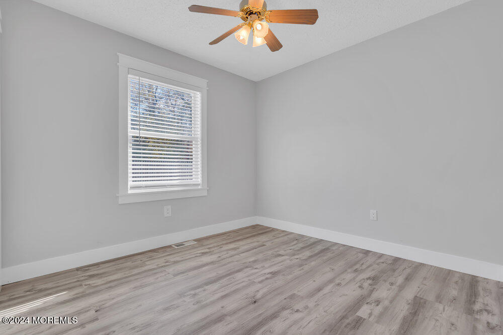 22 Spinnaker Way Waretown, NJ 08758 - Photo 24 of 29 wooden floor in an empty room with a window