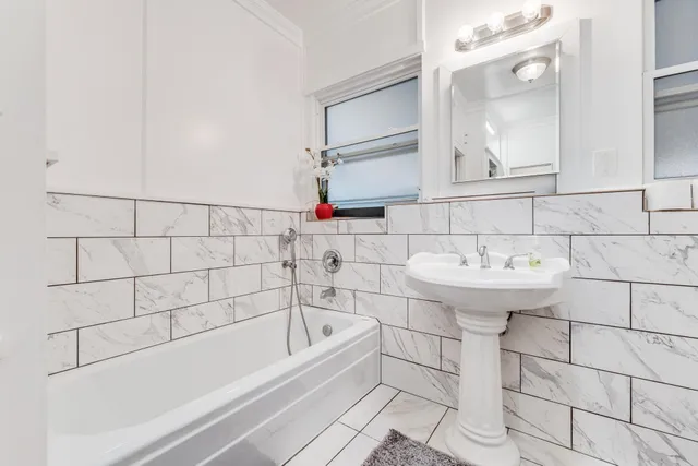 a bedroom with a large bed and a flat tv screen on dresser