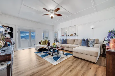 a living room with furniture or chandelier and a wooden floor