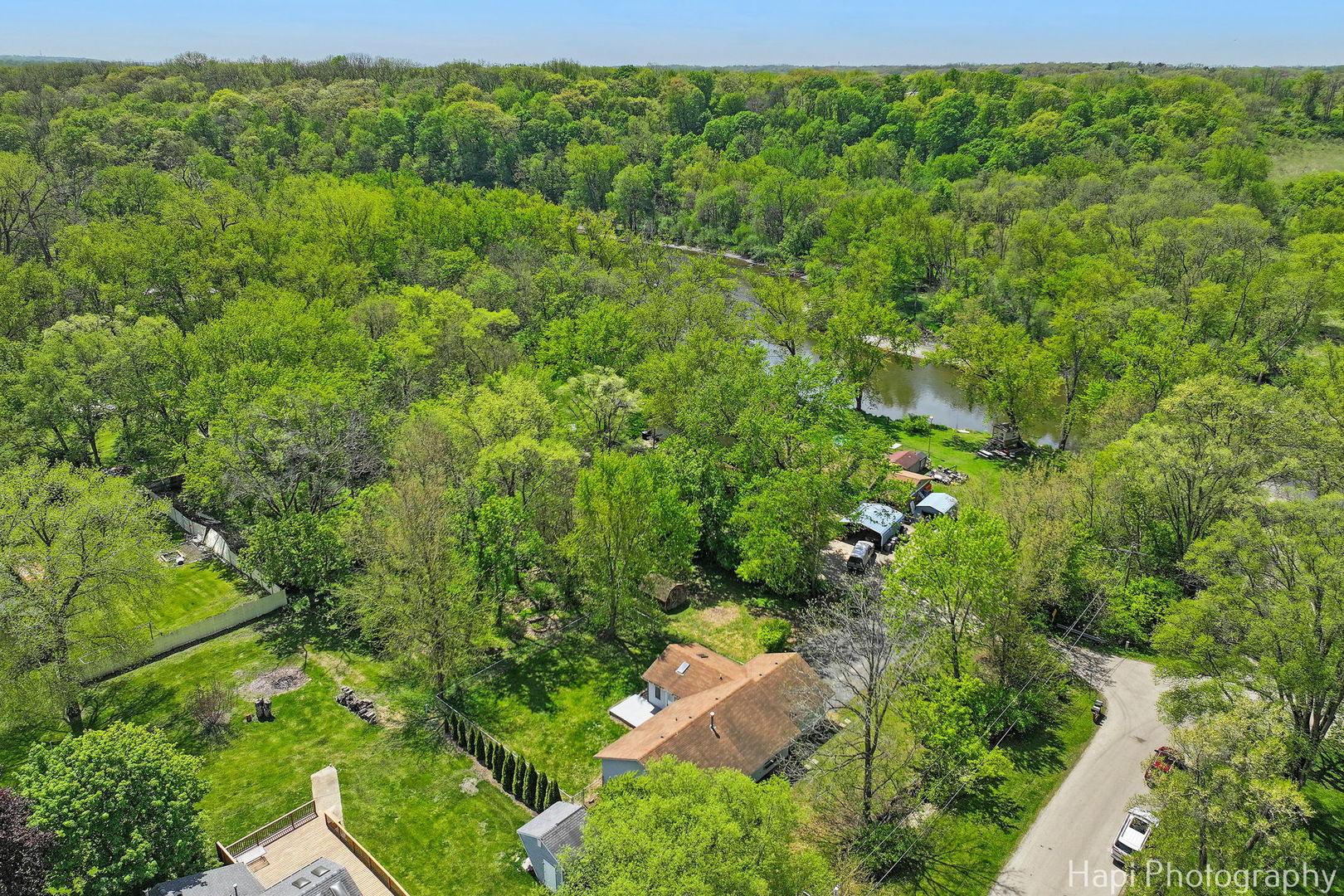 305 Pokagon Drive Algonquin, IL 60102 - Photo 25 of 28 a view of a lush green forest with lawn chairs and plants