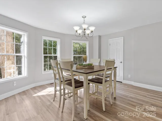 a view of a dining room with furniture a chandelier and wooden floor