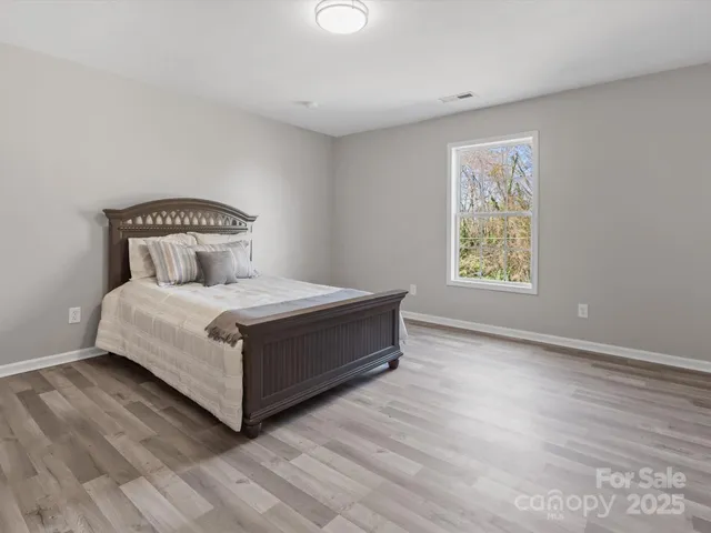 a large bed sitting in a bedroom next to a window