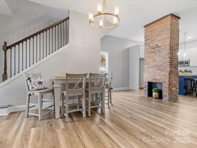 a dining room with furniture wooden floor a fireplace and a chandelier