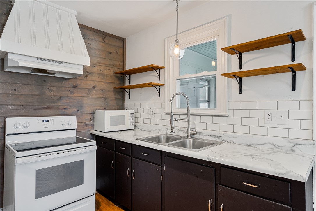 419 Whitehall Road Anderson, SC 29625 - Photo 11 of 28 A well-appointed kitchen features open shelving, subway tile, and wood plank accents for a modern feel.