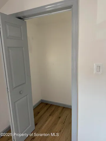 a view of walk in closet with wooden floor